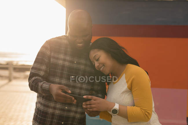 Casal feliz usando calçadão de telefone móvel — Fotografia de Stock
