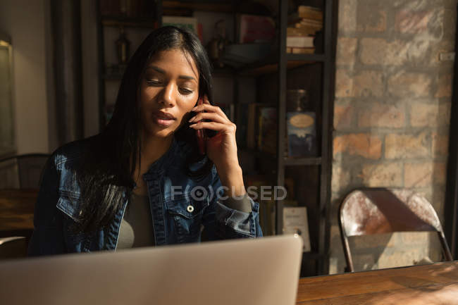 Beautiful woman talking on mobile phone in cafe — Stock Photo