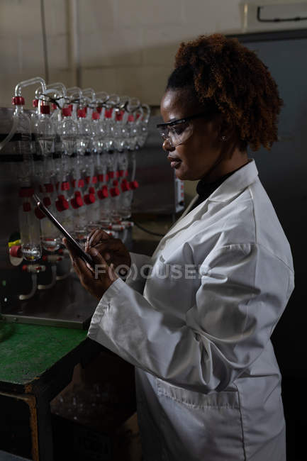 Side view of female worker using digital tablet in factory — Stock Photo