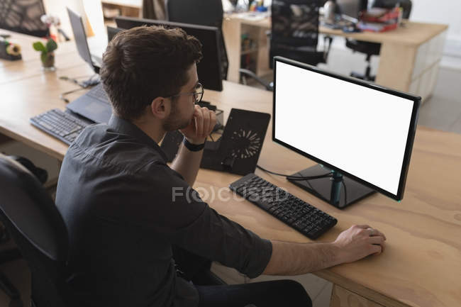 Ejecutivo masculino trabajando en el escritorio en la oficina - foto de stock