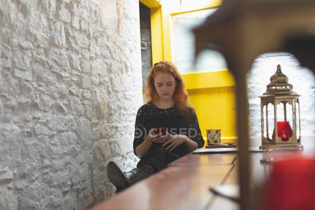 Rothaarige Frau benutzt Handy im Café — Stockfoto