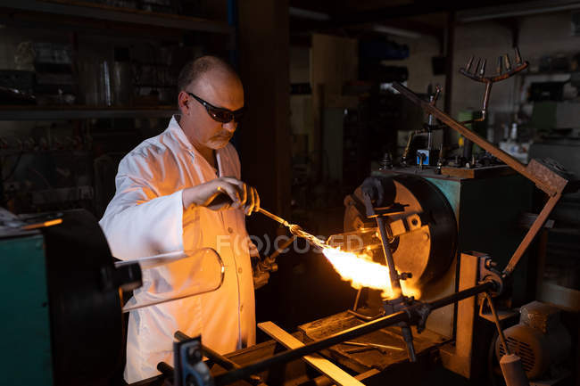 Trabalhador masculino usando tocha de soldagem na fábrica de vidro — Fotografia de Stock