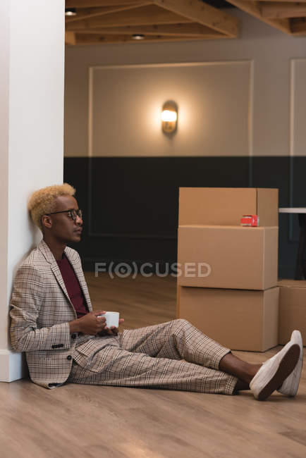 Seitenansicht eines Geschäftsmannes beim Kaffee im Büro — Stockfoto
