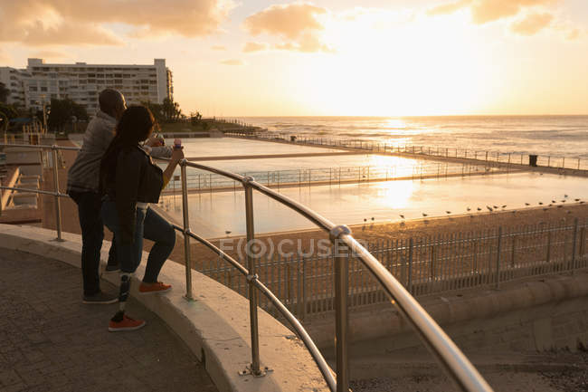 Paar beim Eis essen auf der Promenade bei Sonnenuntergang — Stockfoto