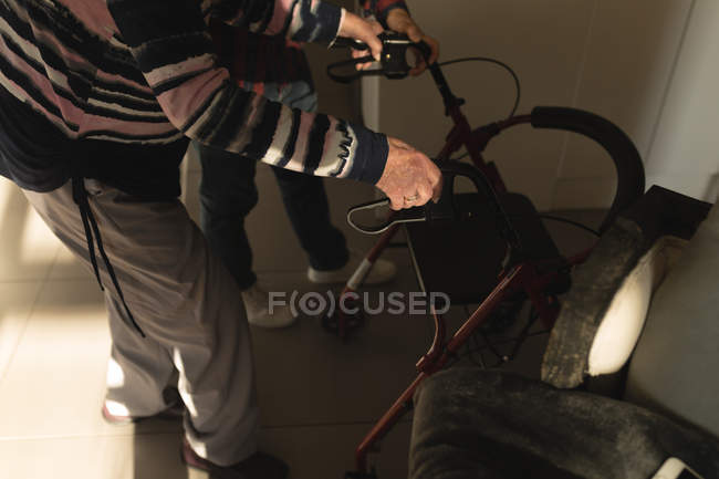 Low section of daughter helping her mother to use walker at home — Stock Photo