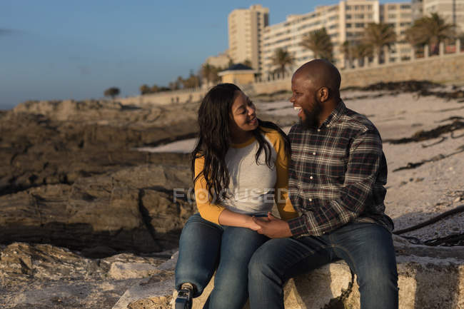 Joyeux couple assis sur la plage — Photo de stock