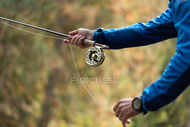 Primo piano del pescatore che detiene una canna da pesca — Foto stock