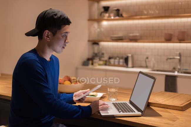 Male executive using laptop in office cafeteria — Stock Photo
