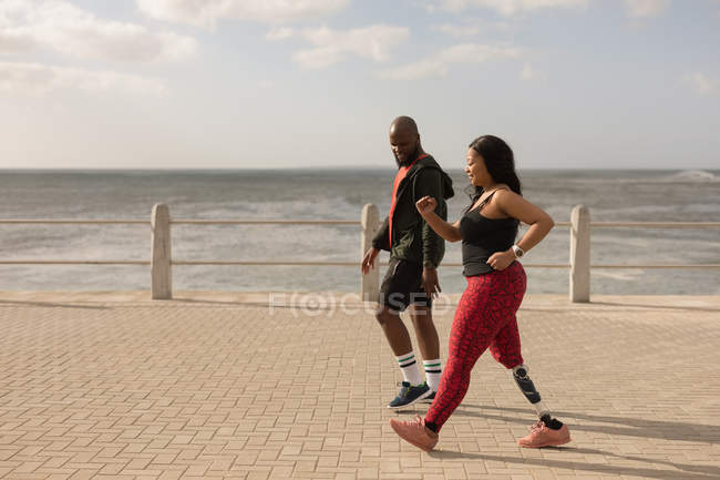 Couple jogging on promenade on a sunny day — Stock Photo