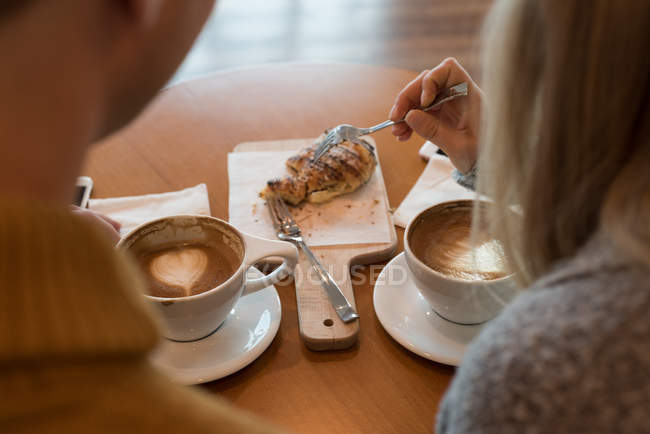 Vista posteriore di coppia che ha cibo dolce in caffè — Foto stock