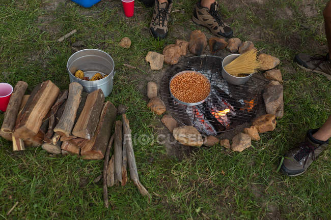 Alimentos en preparación en hoguera en el camping - foto de stock