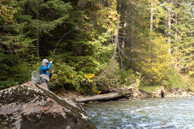Pêcheur voler pêche dans la rivière par jour ensoleillé — Photo de stock