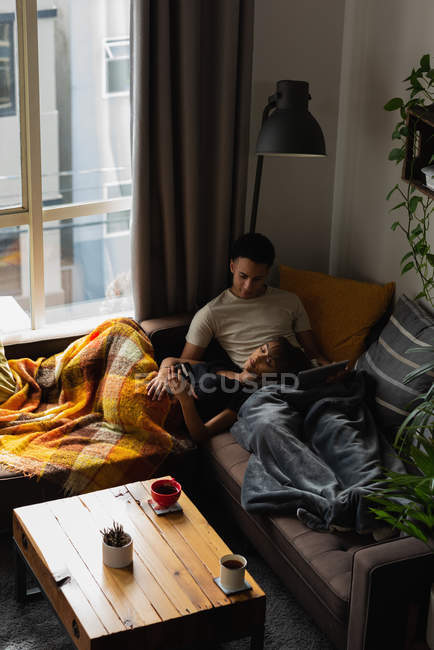 Пара отдыха на диване в гостиной на дому — стоковое фото