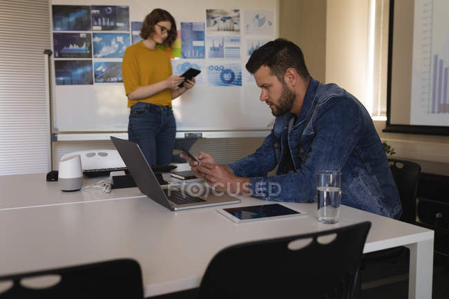 Male executive using mobile phone in office — Stock Photo