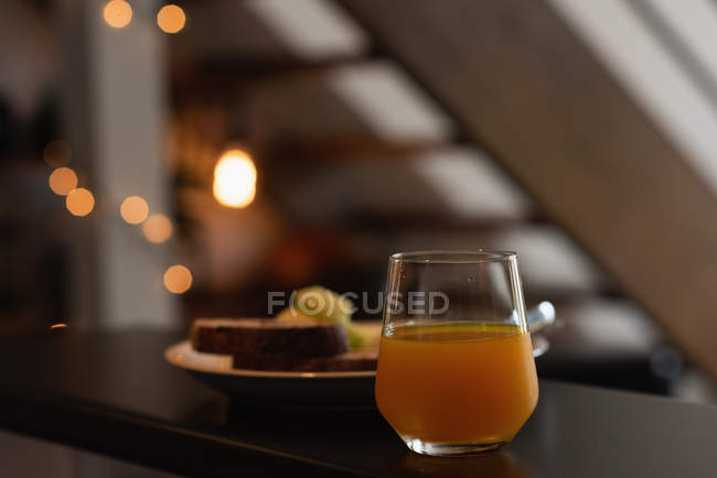 Verre de jus d'orange sur le plan de travail dans la cuisine à la maison — Photo de stock
