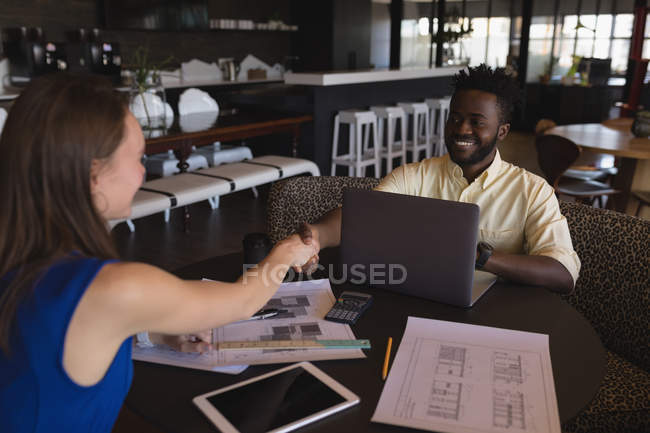 Geschäftskollegen beim Händeschütteln in der Cafeteria im Büro — Stockfoto
