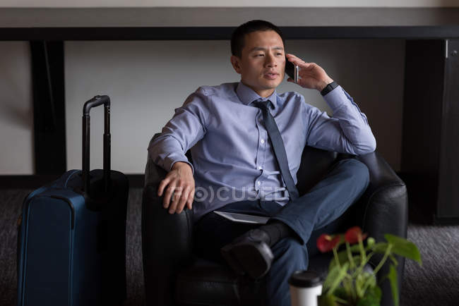 Homme d'affaires parlant sur téléphone portable dans le hall de l'hôtel — Photo de stock