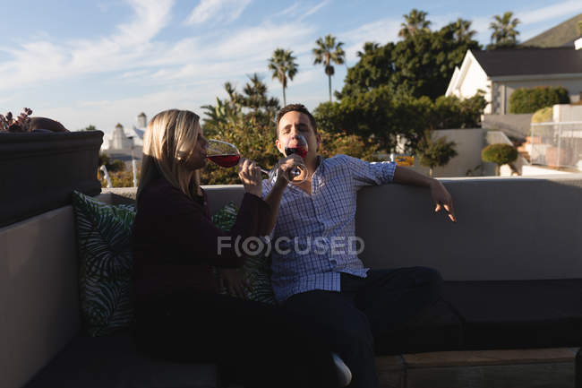 Pareja tomando champán en la terraza en un día soleado - foto de stock