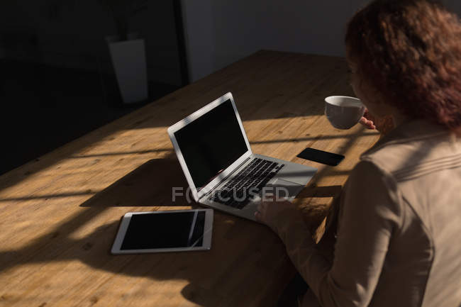 Задний вид женщины-руководителя с помощью ноутбука в конференц-зале в офисе — стоковое фото