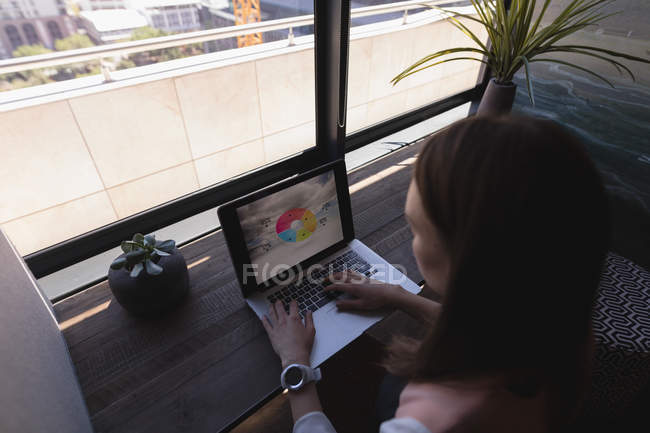 Уважний керівник жіночої статі використовує ноутбук в офісі — стокове фото