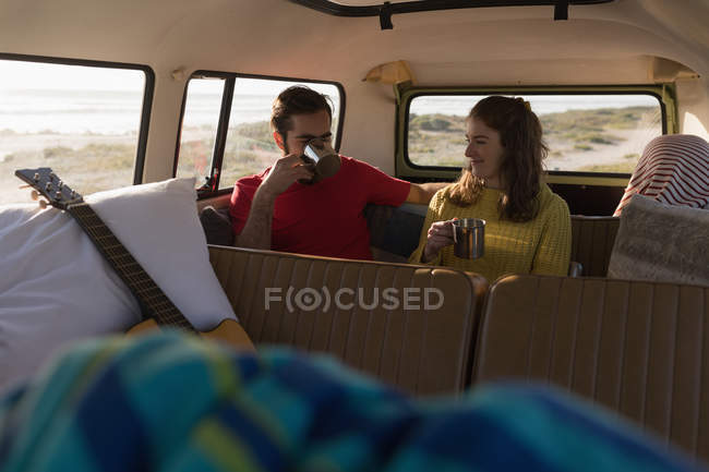 Ehepaar trinkt Kaffee im Lieferwagen auf Roadtrip — Stockfoto