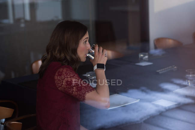 Geschäftsfrau trinkt Wasser im Konferenzraum eines Hotels — Stockfoto
