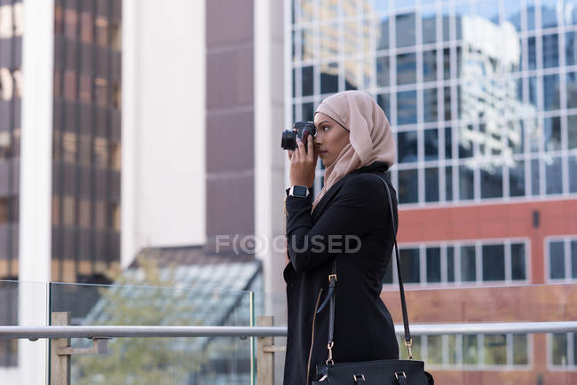 Hijab-Frau klickt Foto in Digitalkamera auf Balkon — Stockfoto