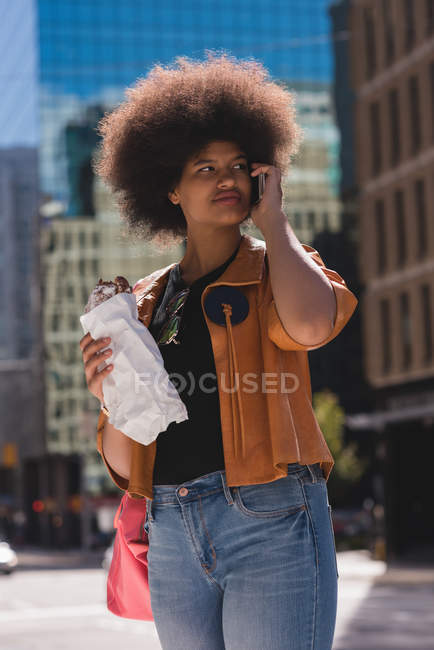 Mujer hablando por teléfono móvil en la ciudad en un día soleado - foto de stock