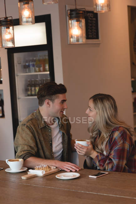 Молодая пара взаимодействует друг с другом в кафе — стоковое фото