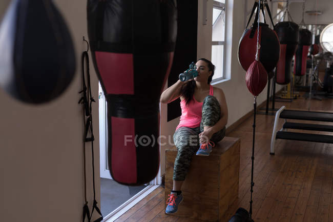 Boxeadora que tiene agua en el gimnasio - foto de stock