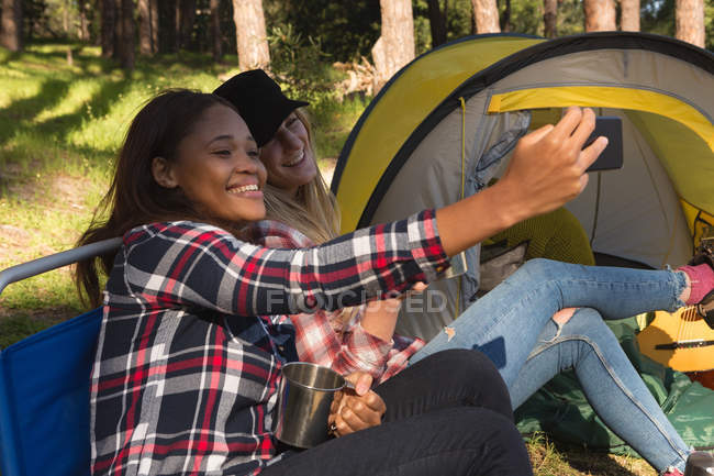 Sorrindo mulher tomando selfie na floresta — Fotografia de Stock
