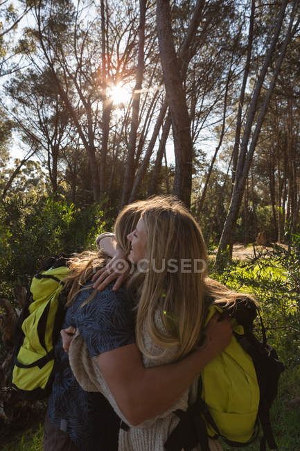 Casal jovem abraçando uns aos outros na floresta — Fotografia de Stock