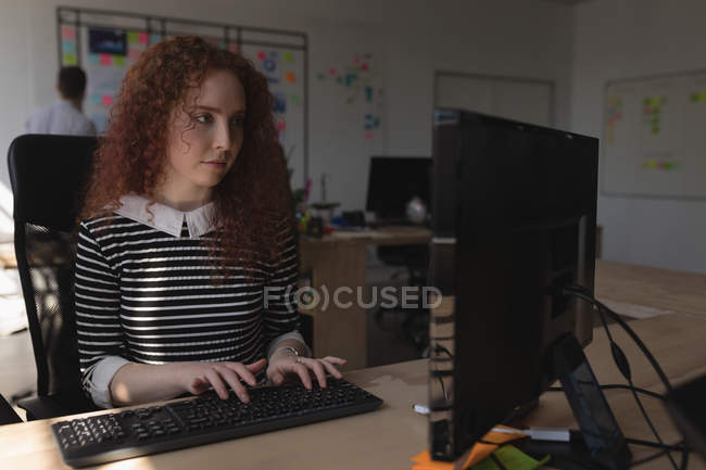 Женщина-руководитель, использующая настольный компьютер за столом в офисе — стоковое фото