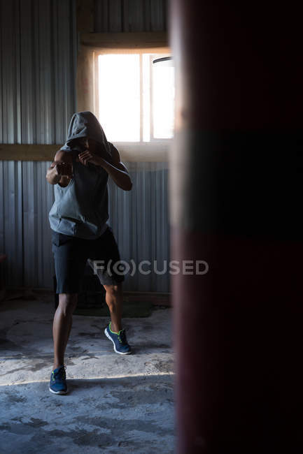 Boxer maschile determinato che pratica pugilato in palestra — Foto stock