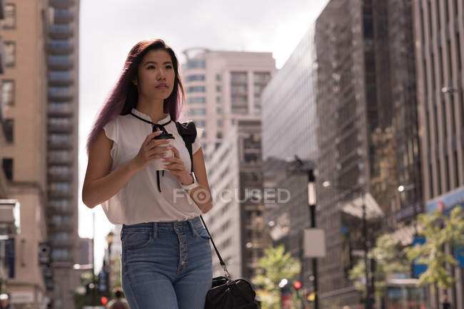 Mulher bonita segurando xícara de café na rua — Fotografia de Stock