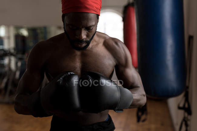 Young male boxer forming hand fist in fitness studio — Stock Photo