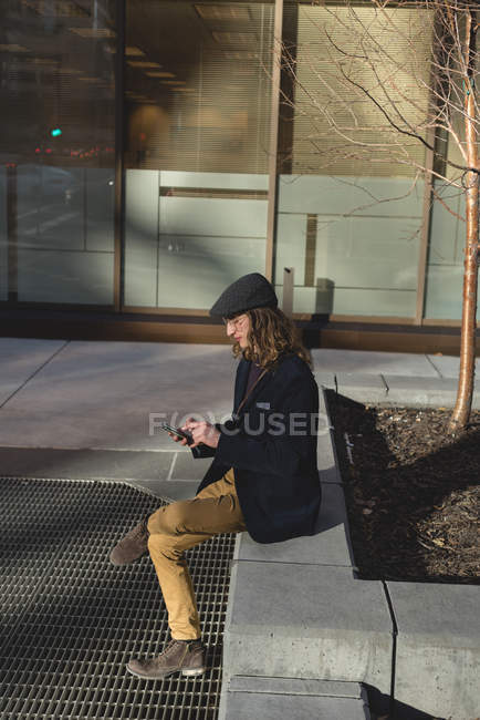 Junger Mann mit Handy in der Stadt — Stockfoto