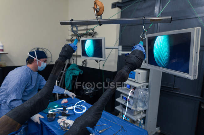 Cirurgião do sexo masculino que utiliza dispositivo médico em sala de operações no hospital — Fotografia de Stock