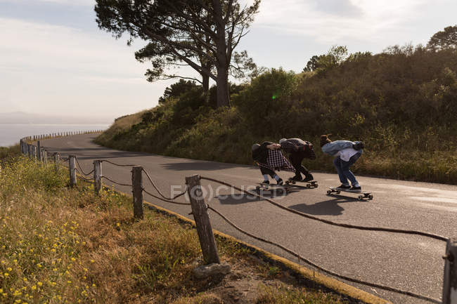 Skateboarders skating on downhill on a sunny day — Stock Photo