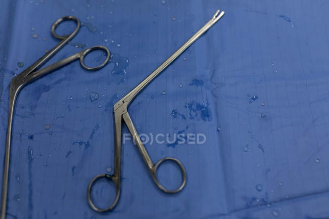 El primer plano de las tijeras quirúrgicas sobre una mesa en el hospital - foto de stock