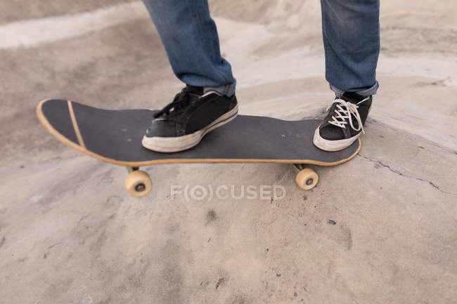 Primer plano del skateboarding de hombre en el parque de skate - foto de stock