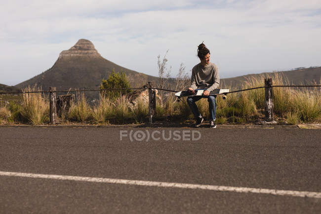 Young male skateboarder sitting on downhill — Stock Photo