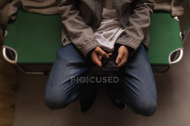 Sección media del hombre usando el teléfono móvil en el taller - foto de stock