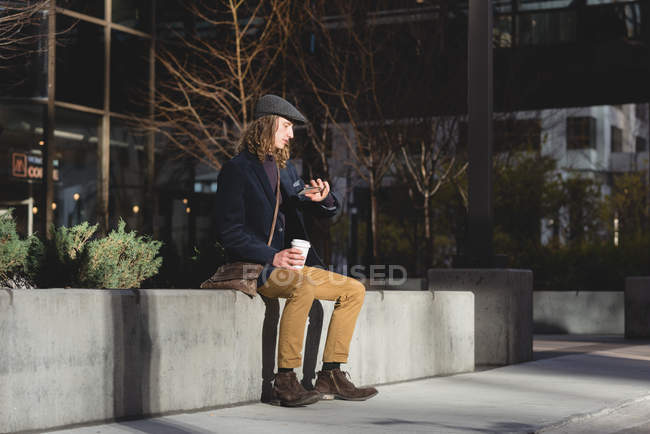 Young man checking time on watch in the city — Stock Photo