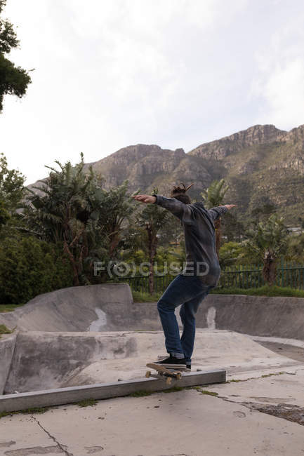 Вид ззаду на скейтбординг людини в парку скейтбордів — стокове фото