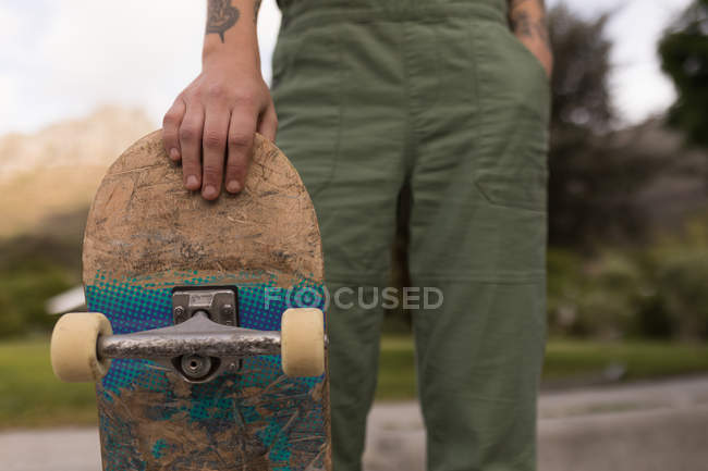 Gros plan de la femme debout avec skateboard au parc de skateboard — Photo de stock