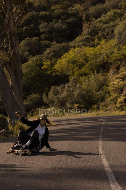 Skateboarder féminin patinant en descente — Photo de stock