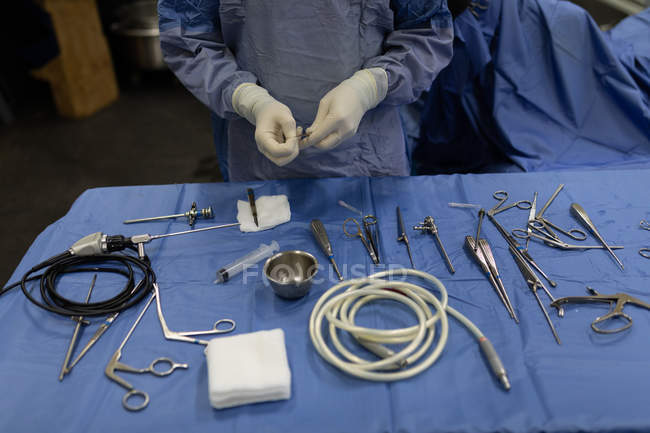 Mid section of surgeon holding medical tools in hospital — Stock Photo