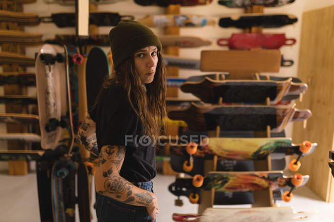 Mujer hermosa de pie y mirando a la cámara en el taller - foto de stock