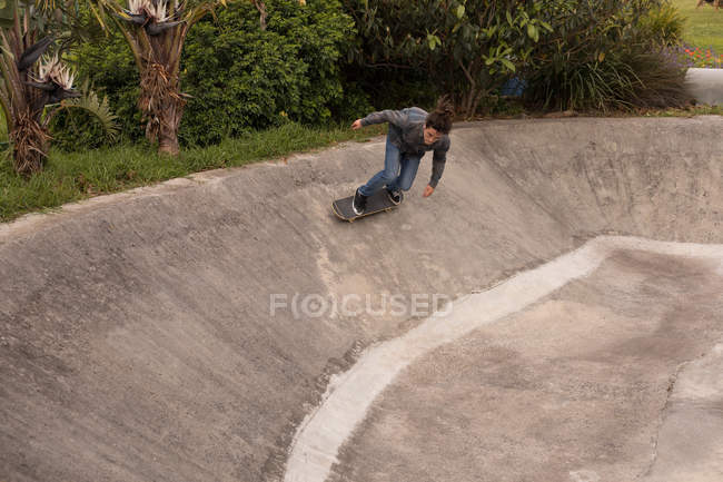 Homem jovem skate no parque de skate — Fotografia de Stock